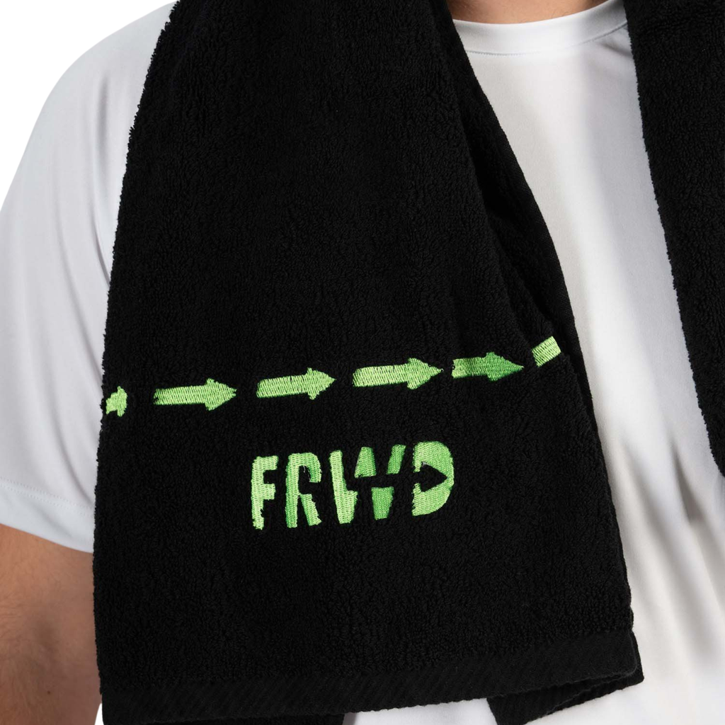 Black towel with green text and arrows held by a person wearing a white shirt.